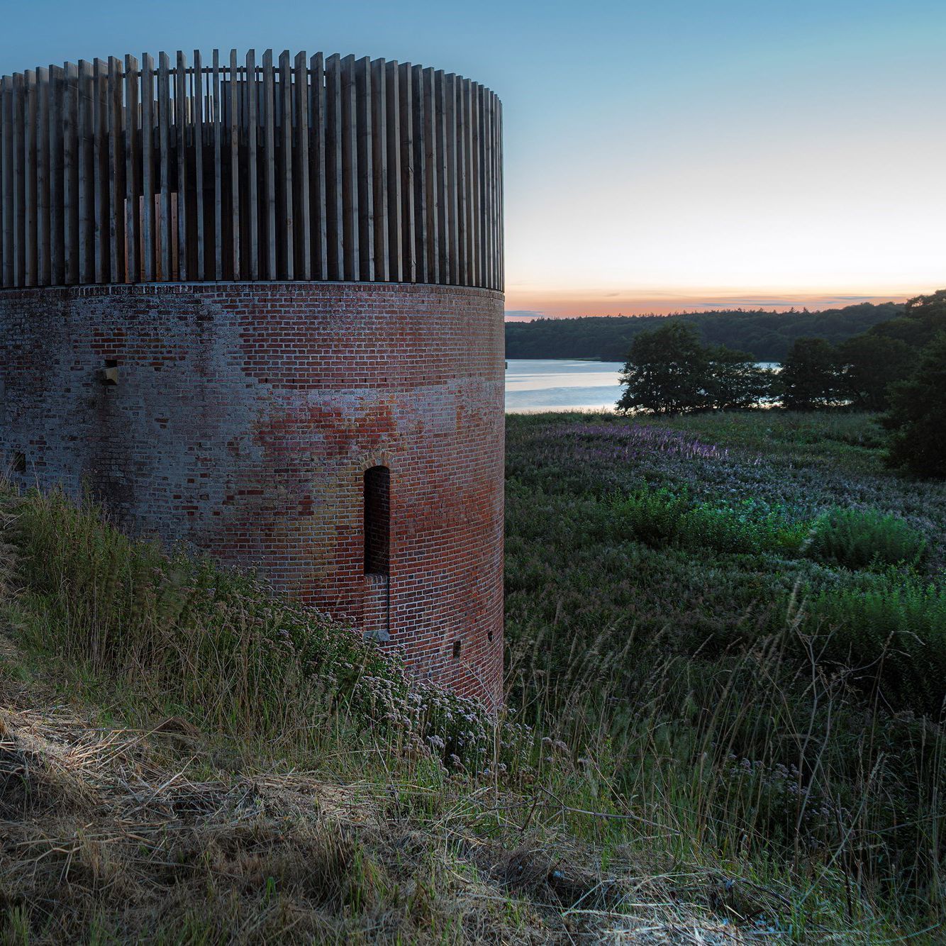 Solnedgangsbillede af Hald Slot med kig til Hald Sø