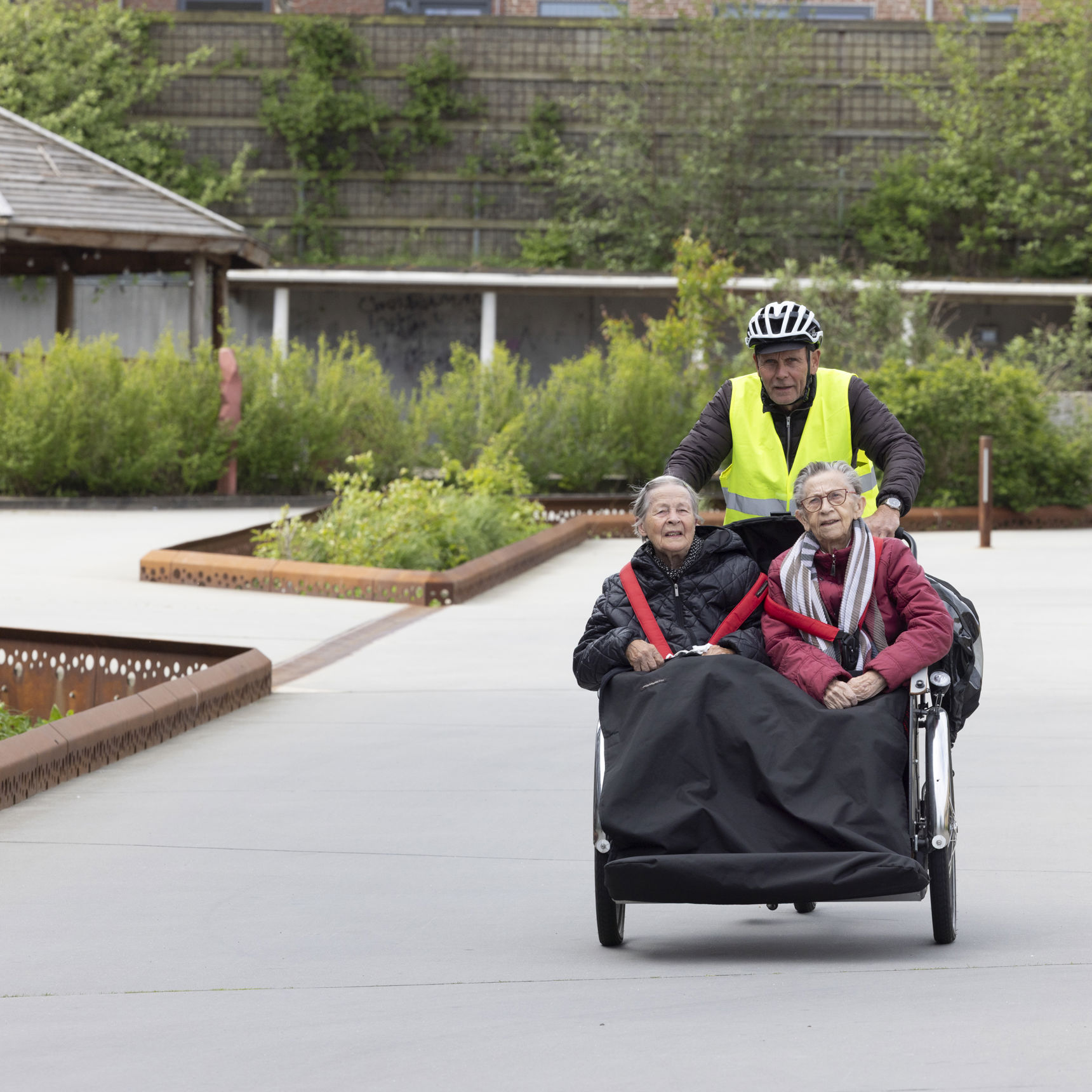 Frivillig cykler med to borgere