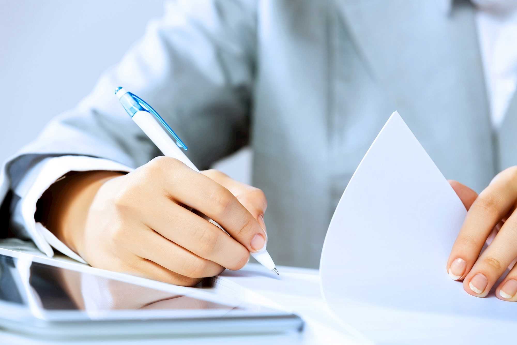 Hånd skriver underskrift med kuglepen