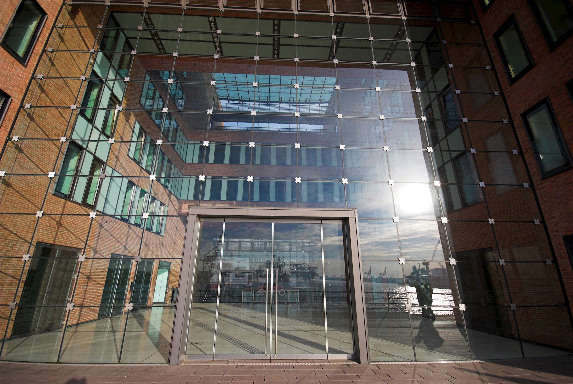 Bygningsfacade. Murstensmure og en glasfacade, er spejlerl lyset