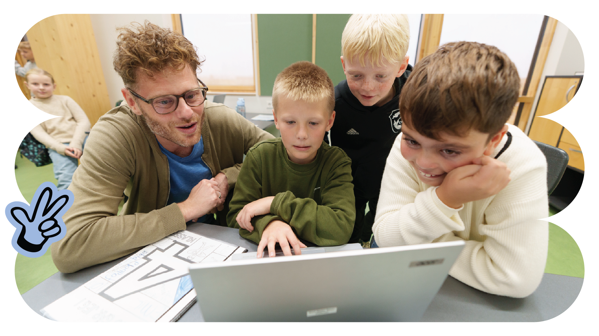 Børn i indskolingen kigger på pc sammen med voksen