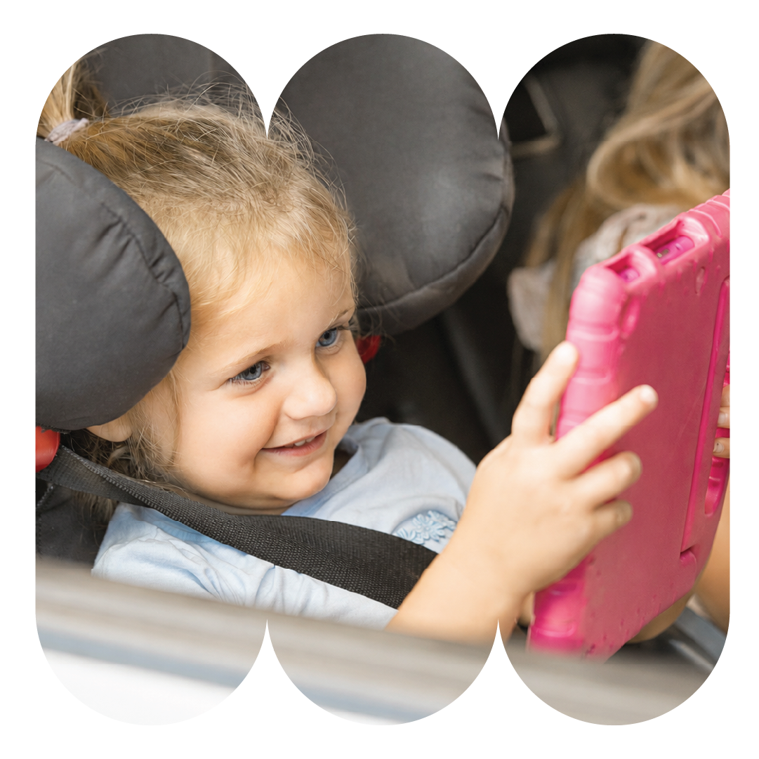 Lille barn kigger på tablet i bilen