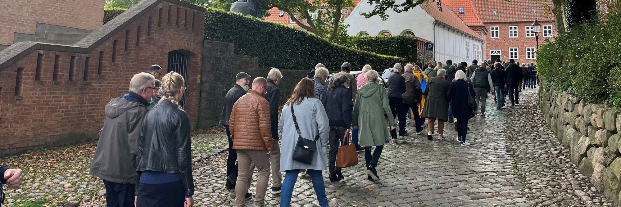 En gruppe voksne personer følger en guide på Grå Brødre Kirkestræde