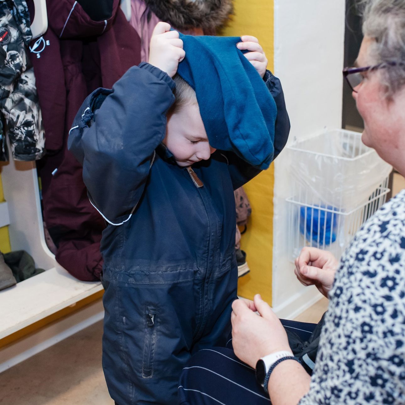 Barn, der tager overtøj på i garderobe