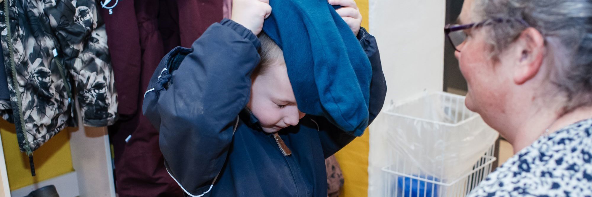 Barn, der tager overtøj på i garderobe