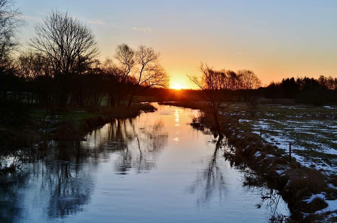Solnedgang over å. Vinter.