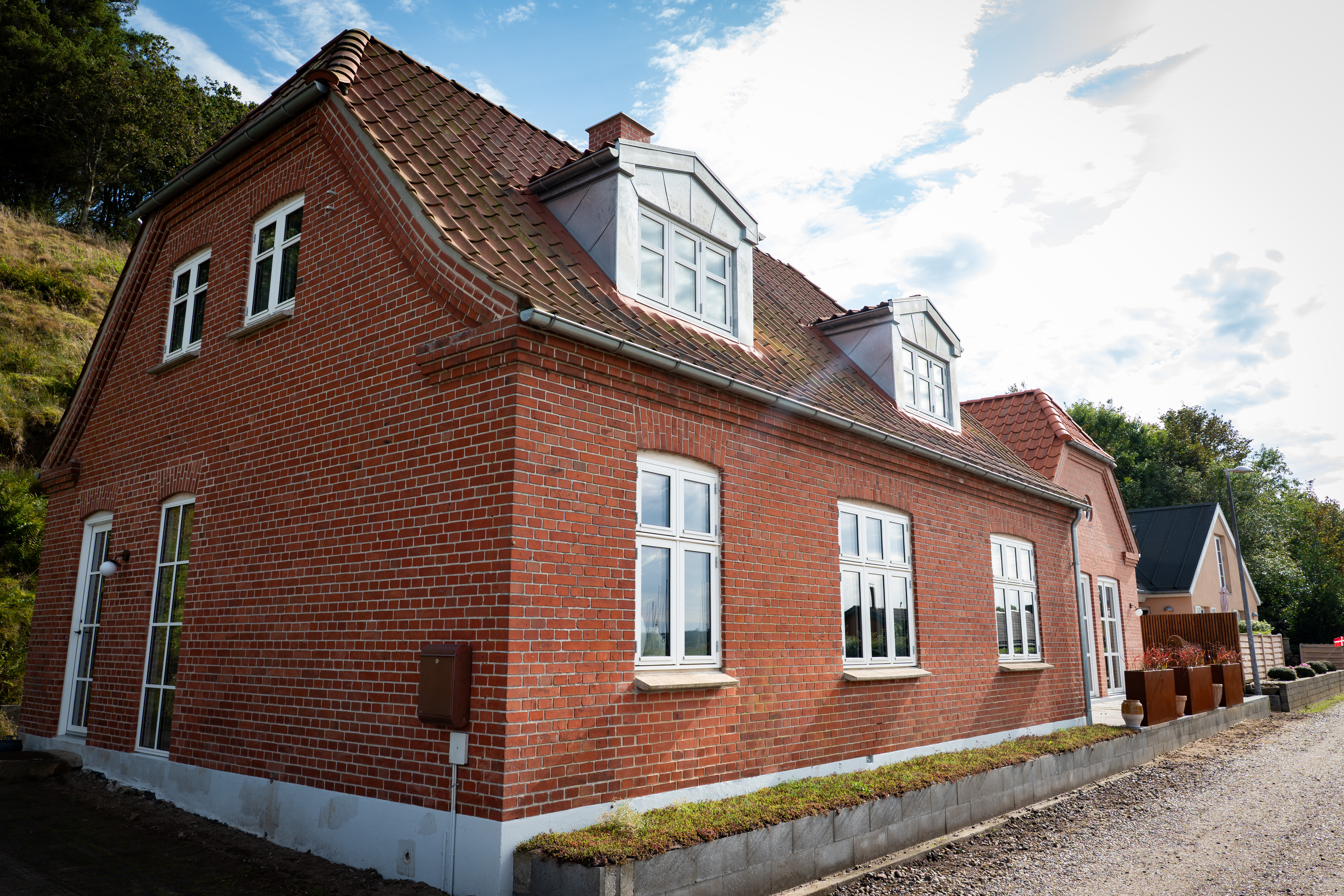 Facade og del af grusvejen foran huset