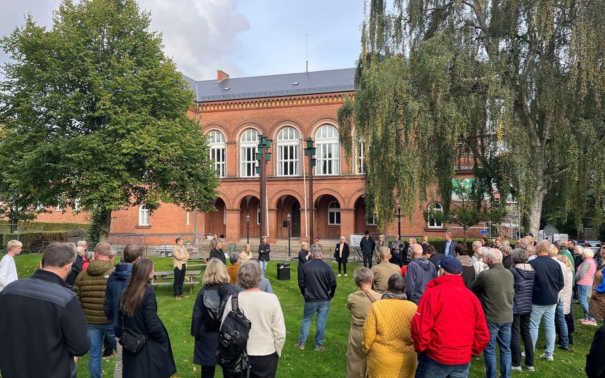 Mange mennesker på græsset foran det gamle Rådhus