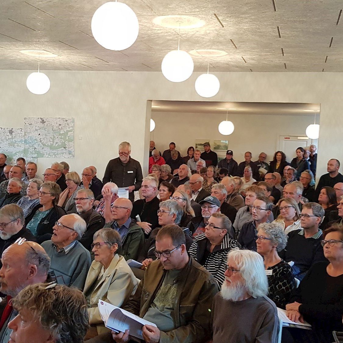 En gruppe voksne tilhørere til et møde