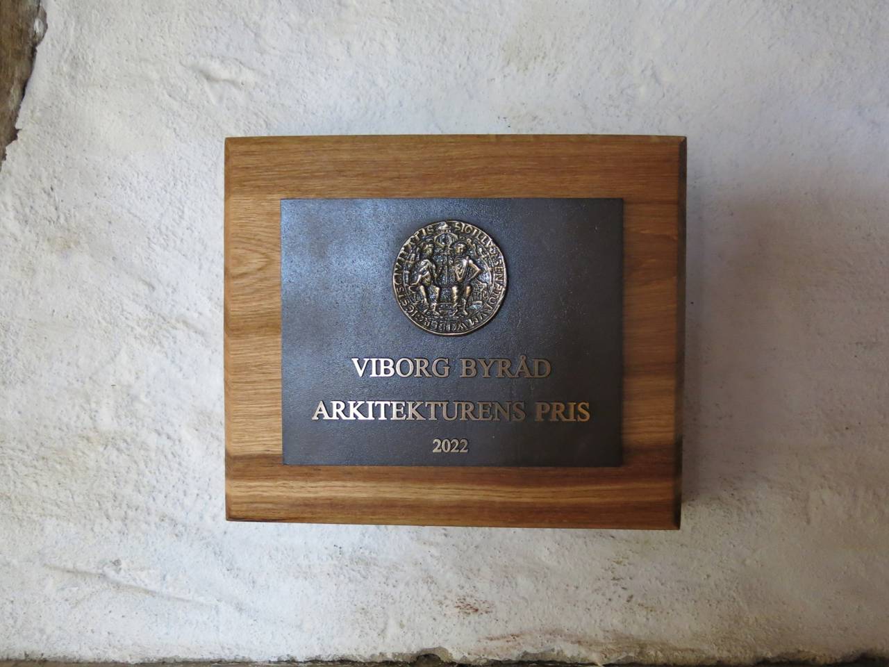 Nærbillede af plaketten, der blev givet for Arkitekturens Pris i 2022, hænger i Hald Laden