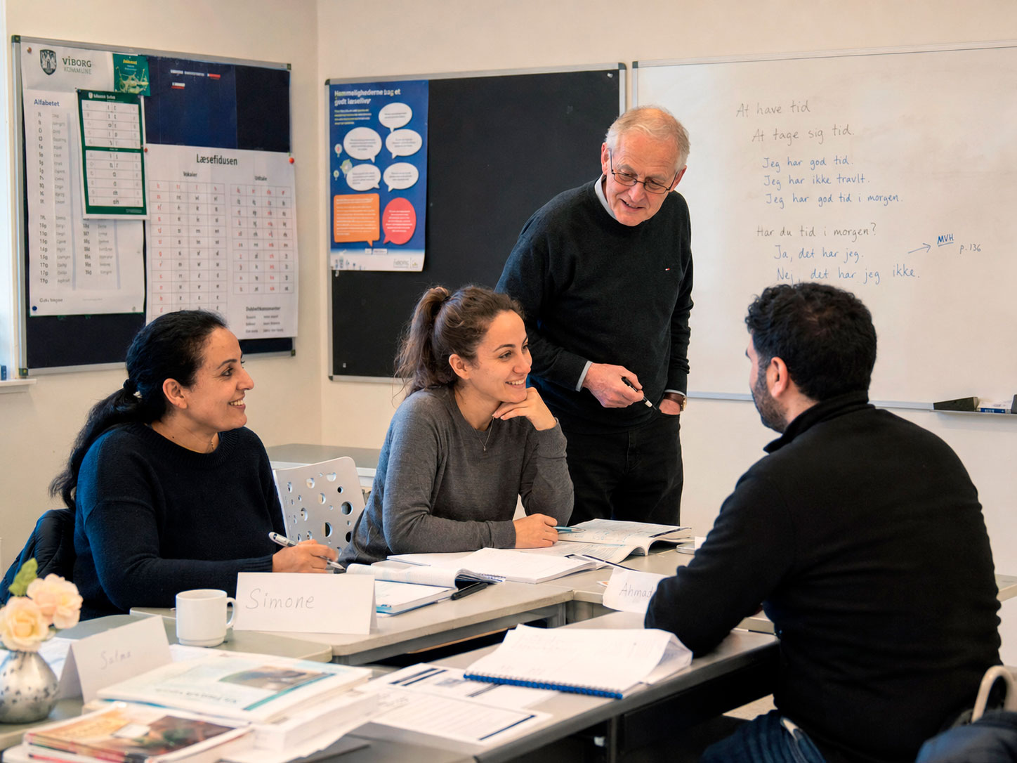 Tre mennesker får undervisning på Sprogskolen