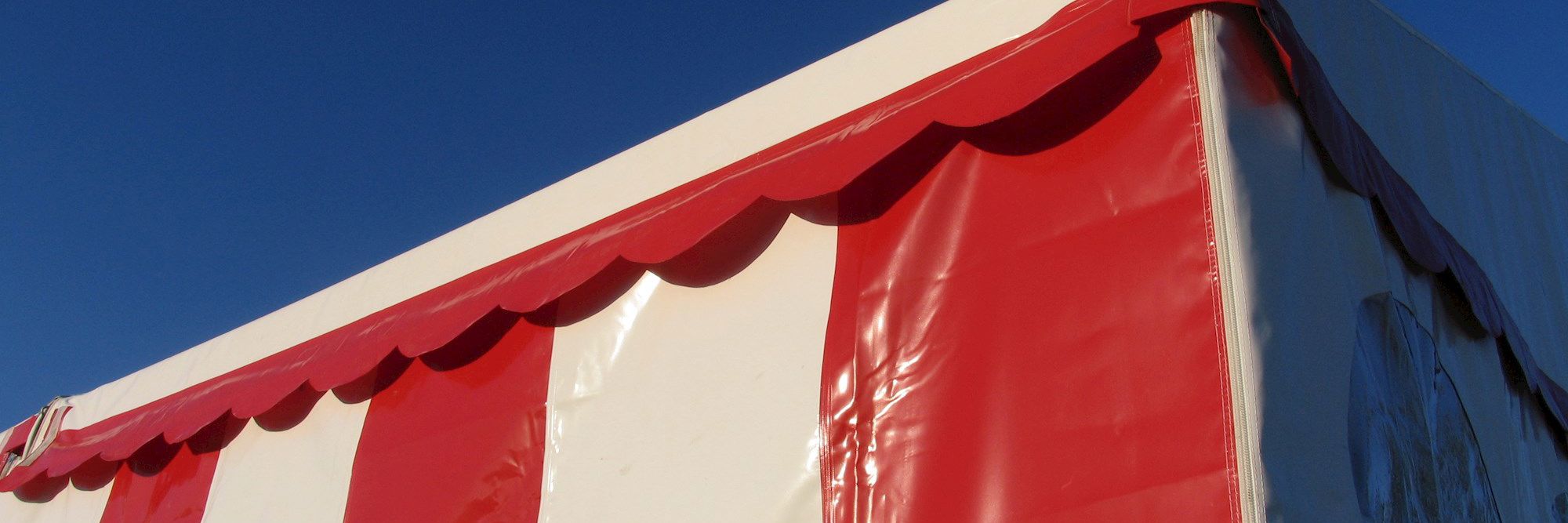 Solidt telt med brede, lodrette striber og guirlande-kant i toppen