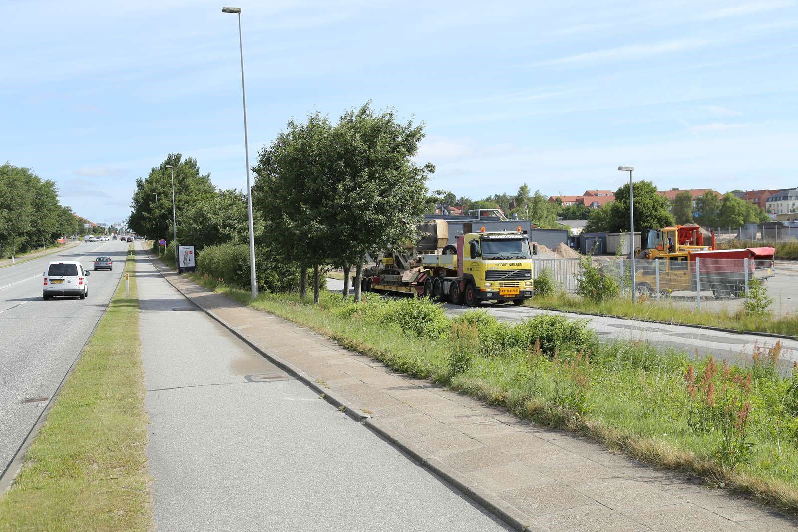 Holdende lastbiler og vej med kørende biler