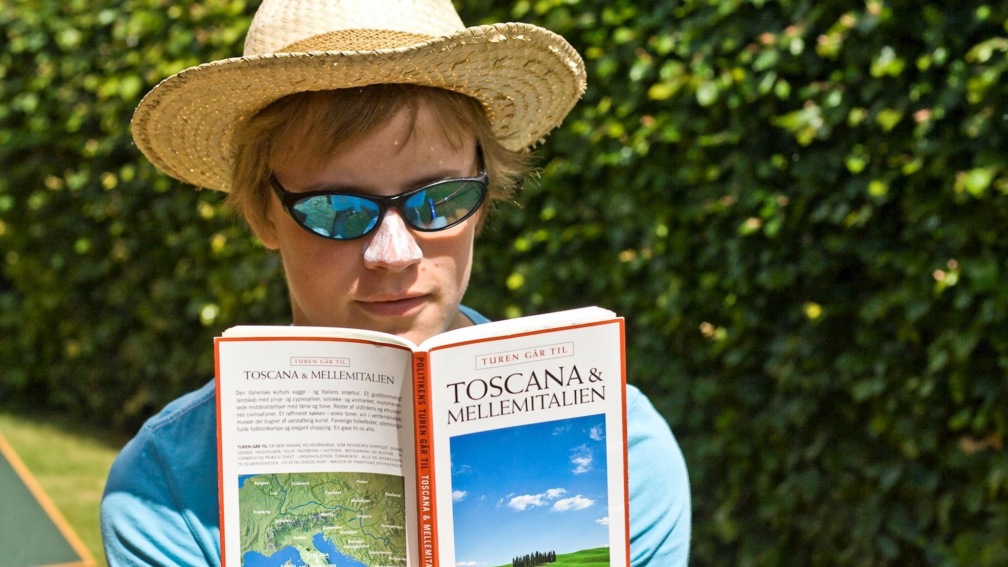 Kvinde læser rejseguide i solskin