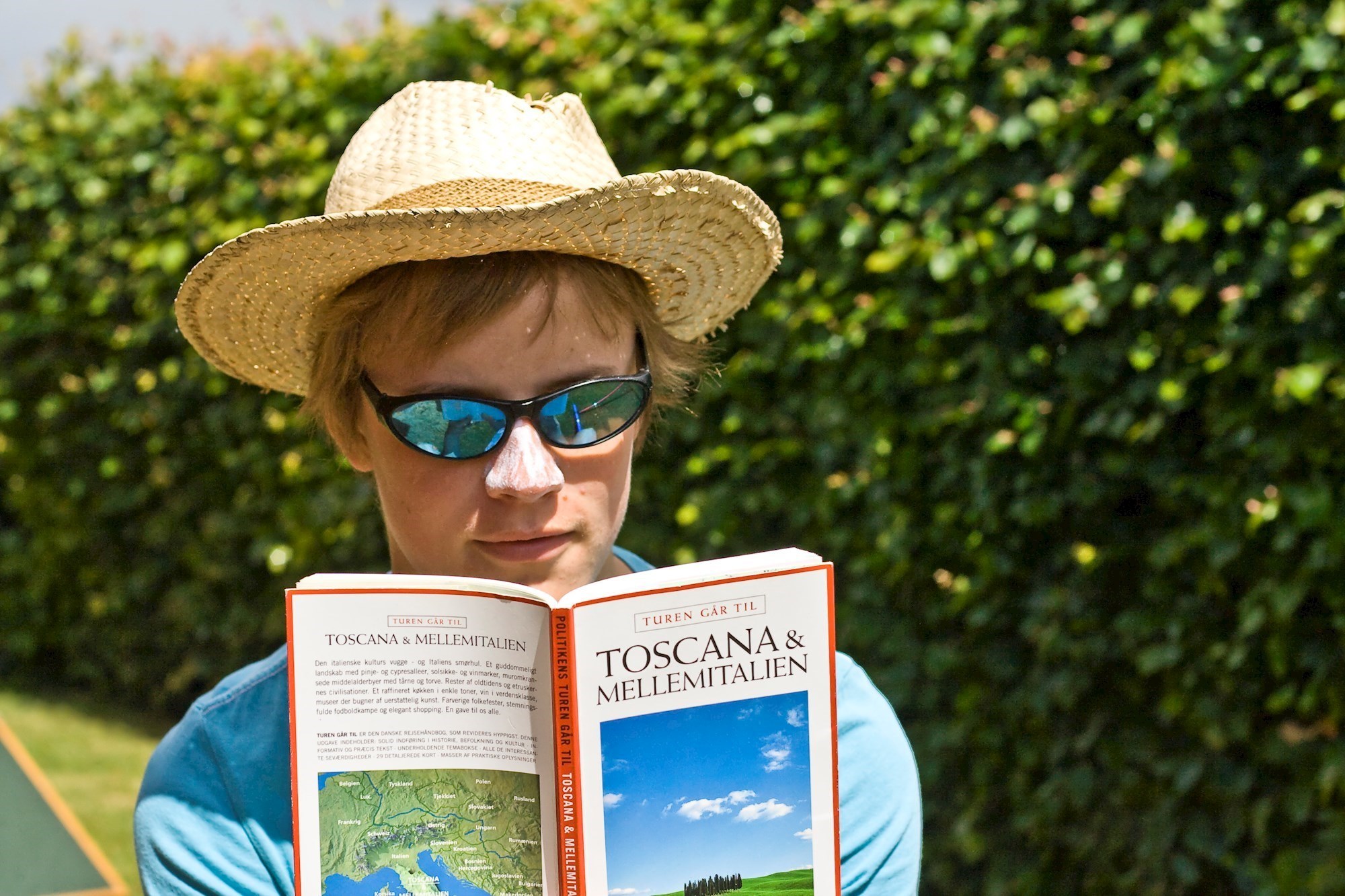 Kvinde læser rejseguide i solskin