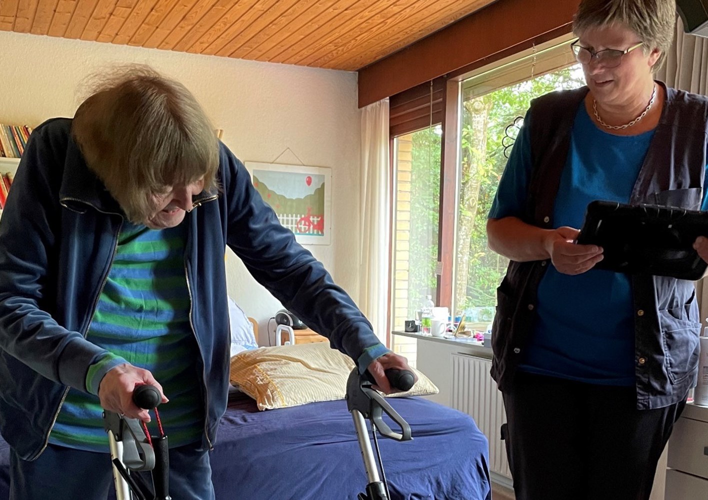 Eva Larsen har god gavn af træningen i sit hjem ved hjælp af træningsplatformen DigiRehab. Hun træner sammen med Jane Nielsen fra hjemmeplejen i Viborg Kommune. Foto: Viborg Kommune.
